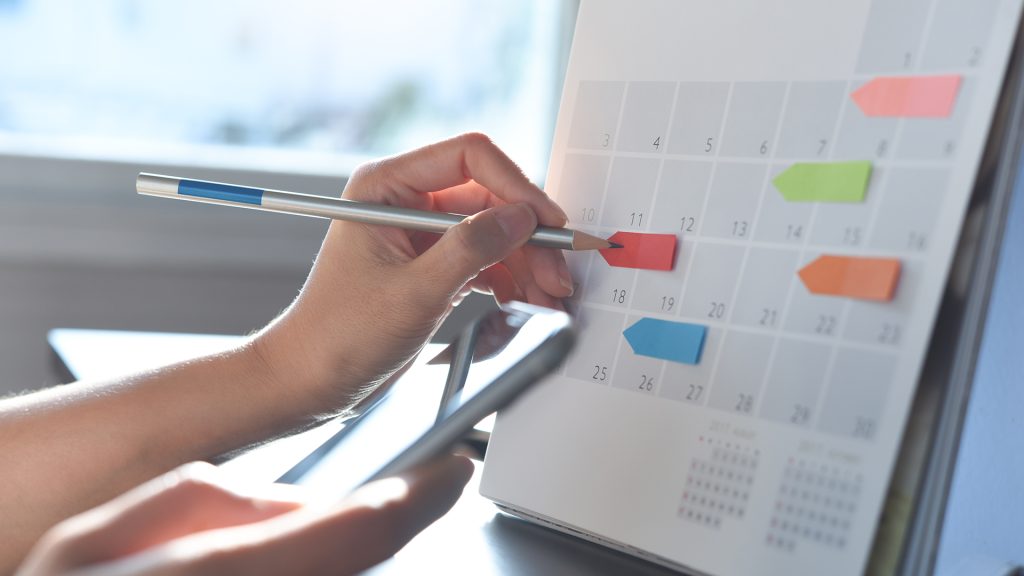 imagine cu o fată care ține un creion pe un calendar