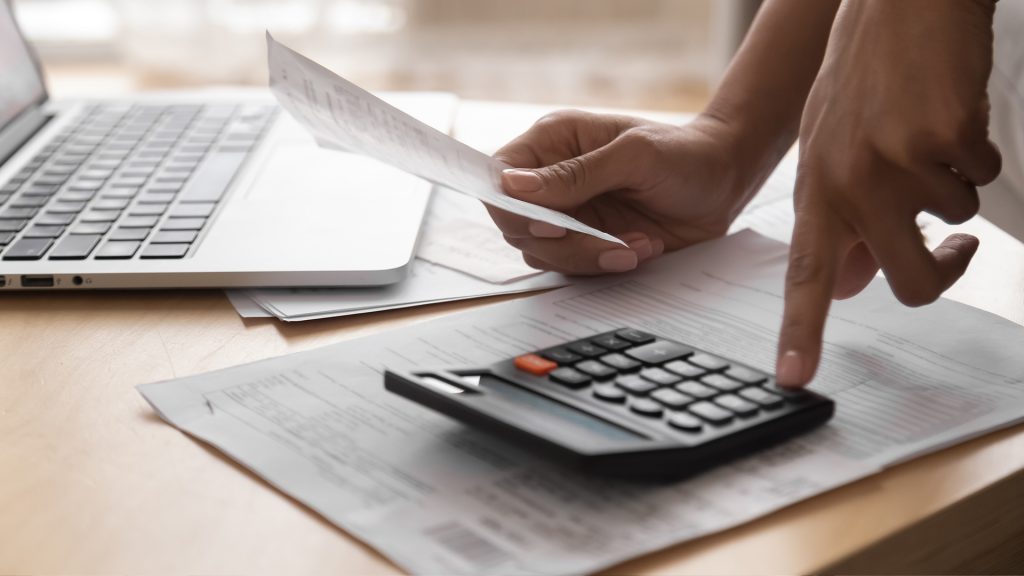 imagine cu o fată care calculează folosind un calculator de mână